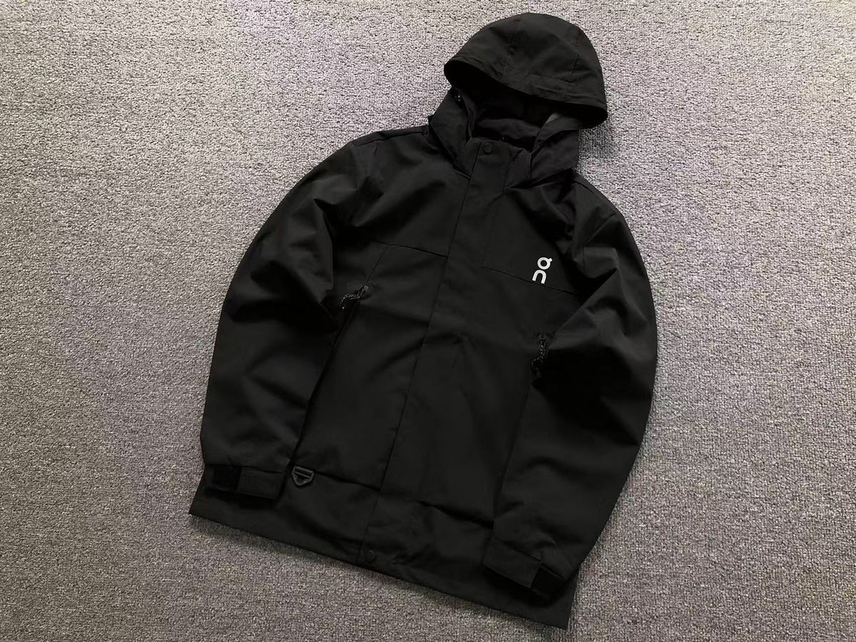 Black hooded shell jacket with zip chest pockets and velcro cuffs