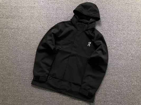 Black hooded shell jacket with zip chest pockets and velcro cuffs