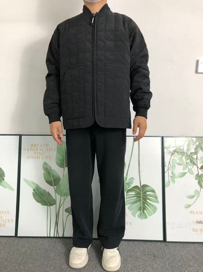 Black quilted liner jacket worn with black trousers, front