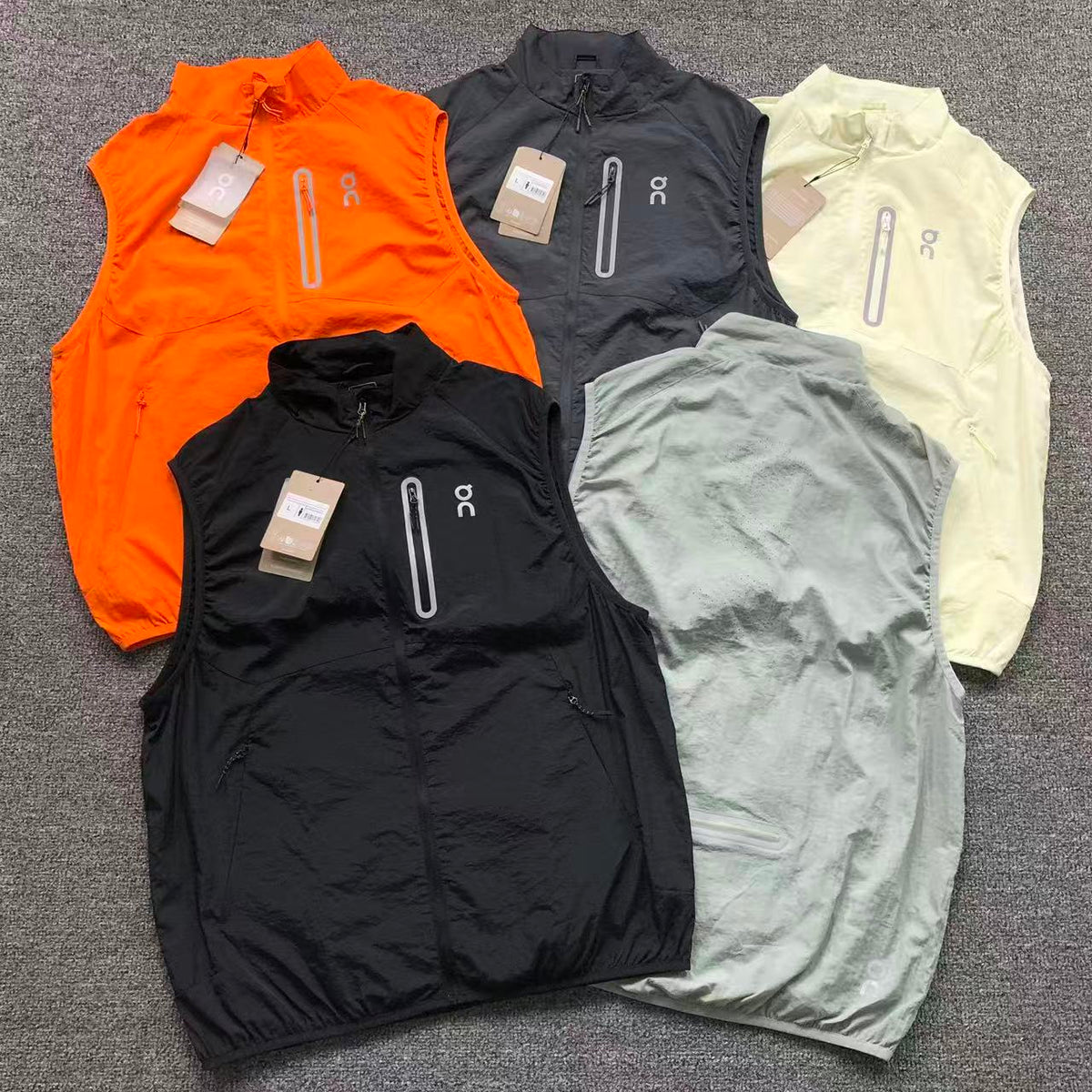 Lightweight running gilets in orange, charcoal, cream and sage