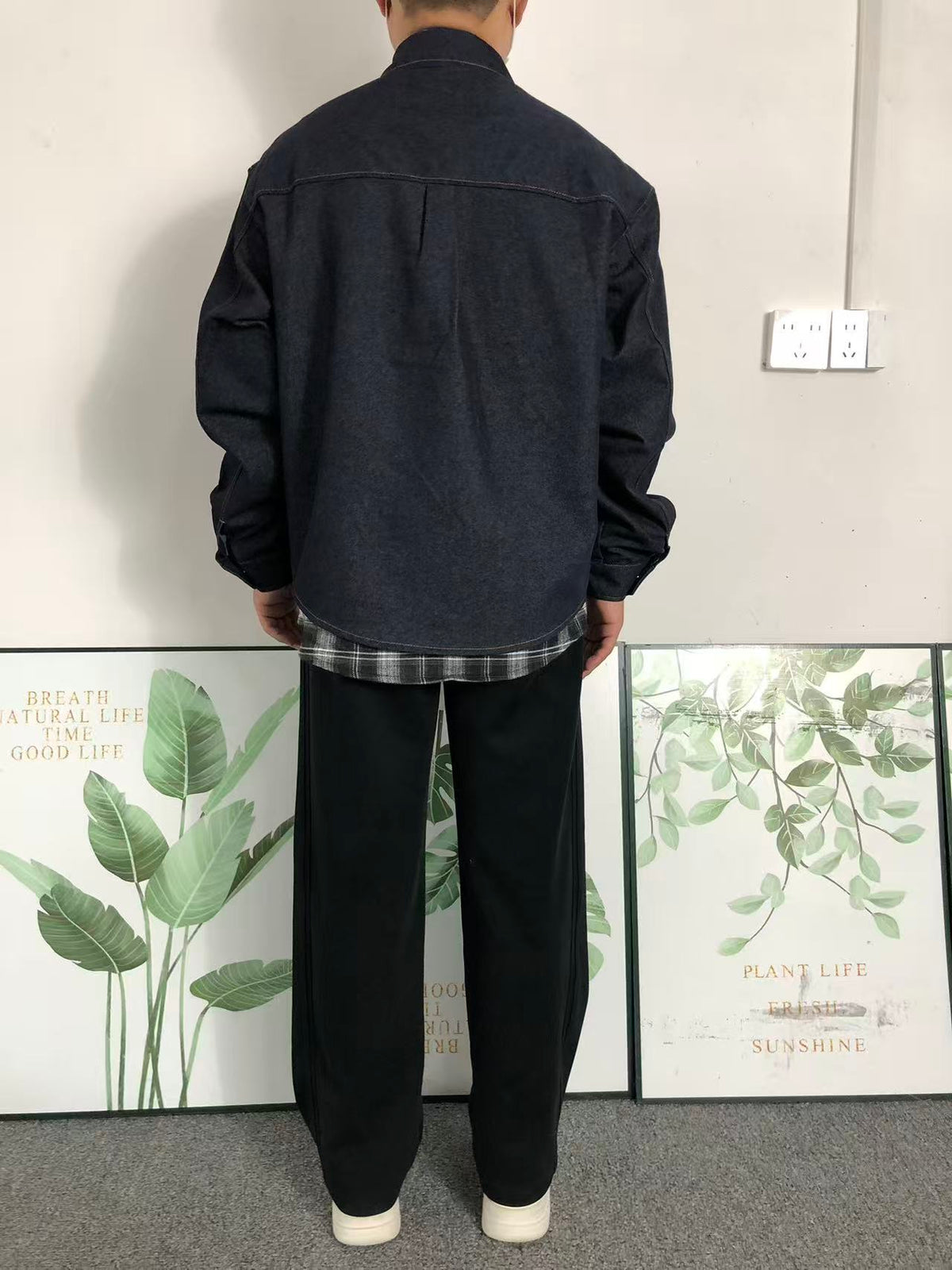 Dark denim shirt jacket worn with black trousers, back
